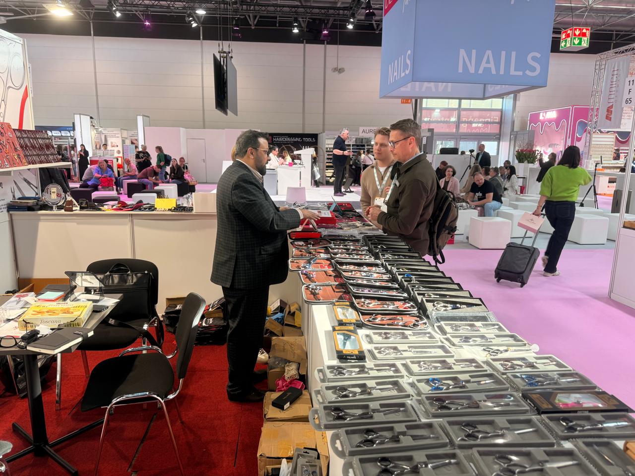 Visitors speak with our team beside the beauty tool displays. Beauty Düsseldorf 2025.