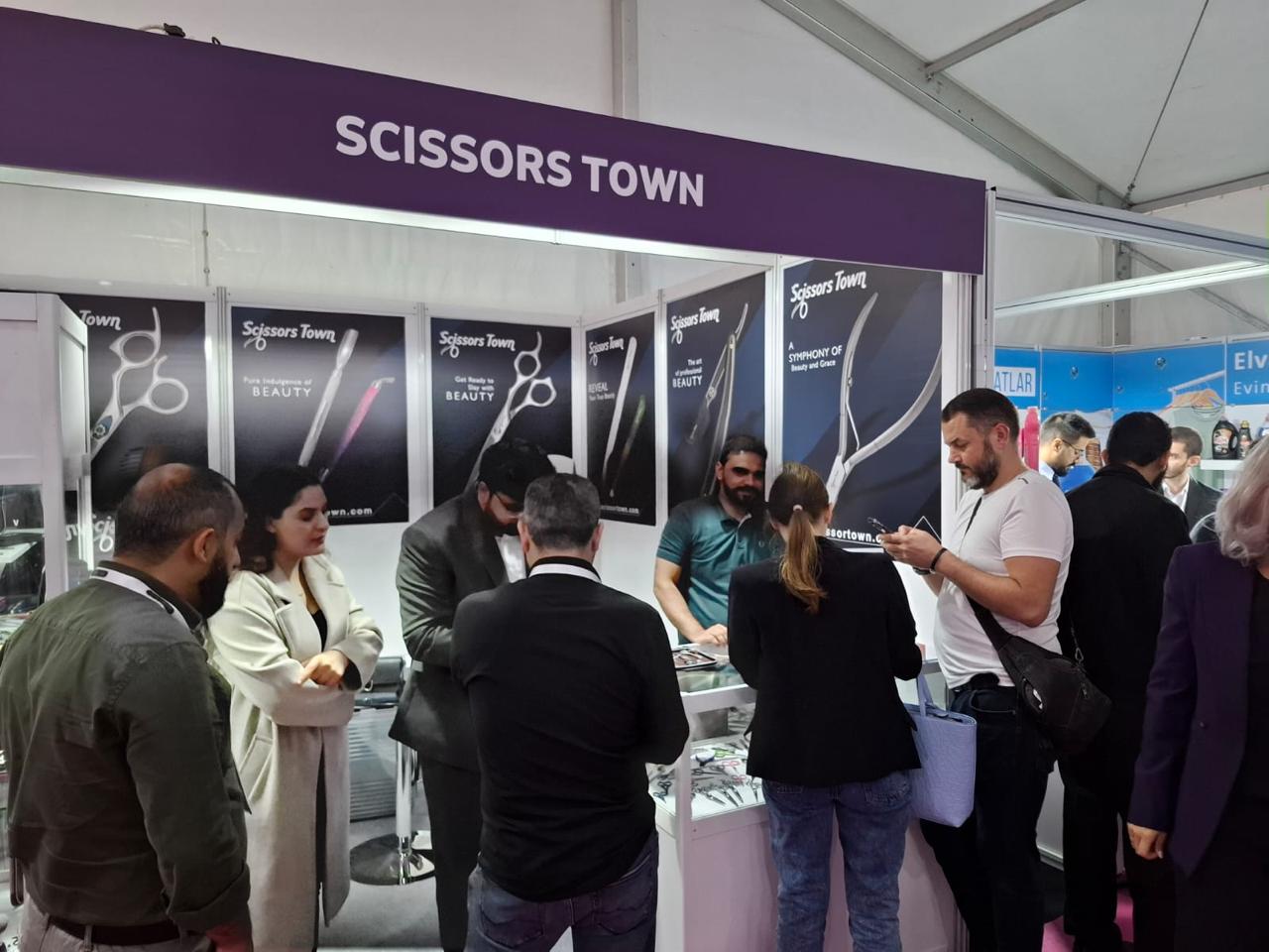 Visitors and the Scissors Town team beside the beauty instrument displays. Beauty Istanbul 2023.