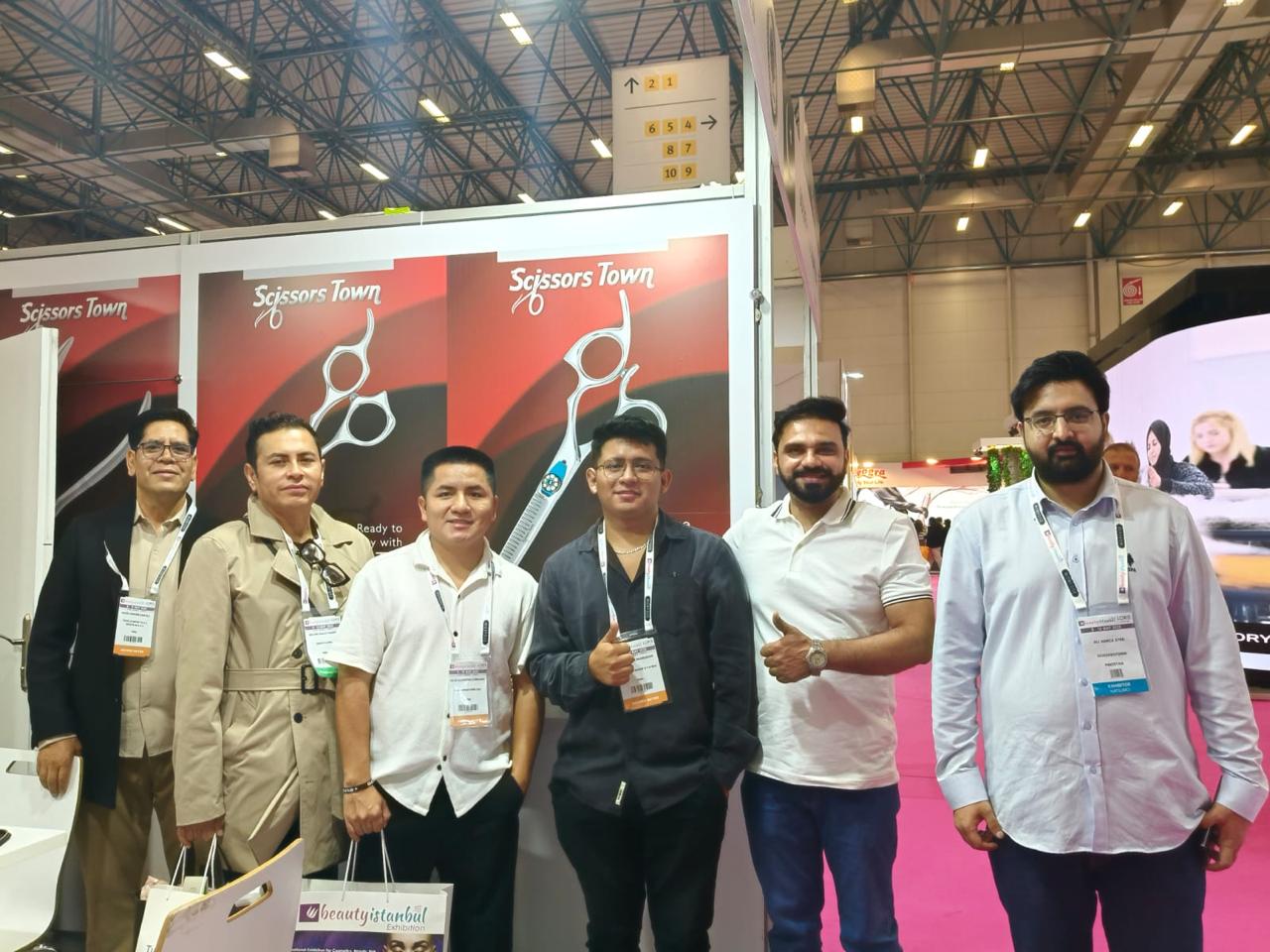 A group photograph beside the Scissors Town scissors display. Beauty Istanbul 2025.