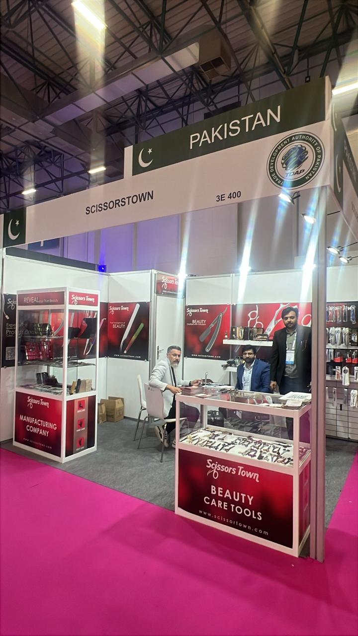 Our team and visitors at the stand, with beauty tools displayed in the cabinets. Beauty Istanbul 2026.